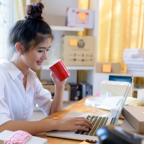 woman sat at desk drinking coffee