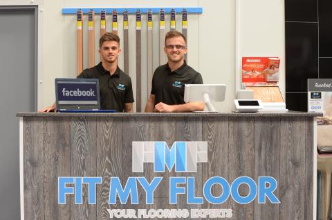 2 men behind a "Fit my floor" counter