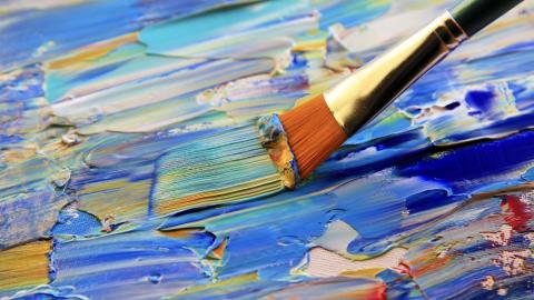 A paintbrush being used on a canvas.