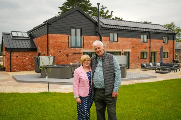 image shows Terry and Lynda Evans in front of the converted barn