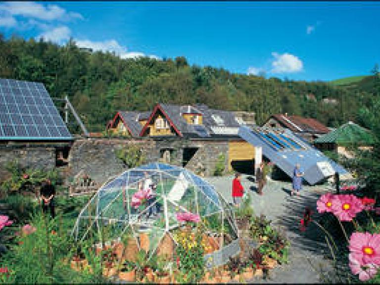image of village garden with solar panels and greenhouse